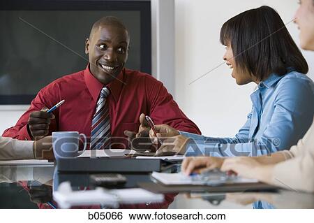 Stock Photograph - Discussion at business meeting smiling. Fotosearch