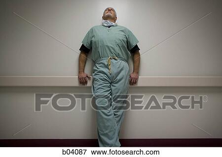 Doctor in scrubs leaning View Large Photo Image Stock Photo - Doctor in scrubs leaning. Fotosearch
