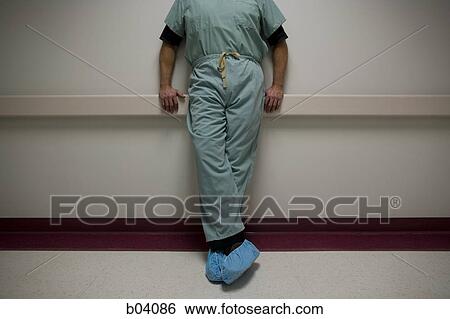 Doctor in scrubs leaning View Large Photo Image Stock Photograph - Doctor in scrubs leaning. Fotosearch