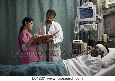 Doctor looking at medical chart of boy in hospital bed View Large Photo Image Stock Photo - Doctor looking at medical chart of boy in hospital bed. Fotosearch