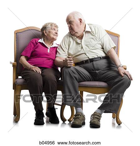 Stock Photograph - Elderly couple sitting in armchairs embracing. Fotosearch