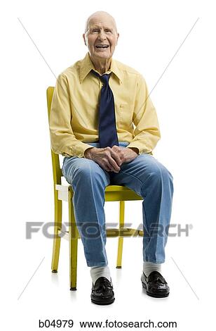 Stock Photo - Elderly man sitting in yellow chair smiling. Fotosearch