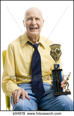 Elderly man with baseball trophy sitting in chair smiling View Large Photo Image Stock Photo - Elderly man with baseball trophy sitting in chair smiling. Fotosearch