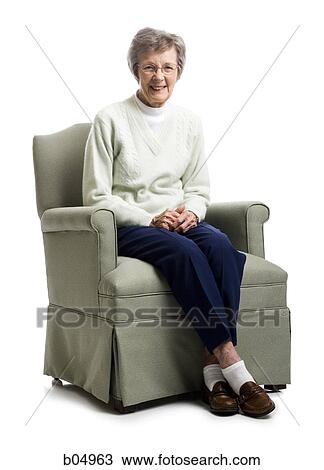 Elderly woman sitting in an armchair smiling View Large Photo Image Stock Image - Elderly woman sitting in an armchair smiling. Fotosearch