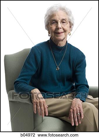 Elderly woman sitting in an armchair smiling View Large Photo Image Stock Image - Elderly woman sitting in an armchair smiling. Fotosearch