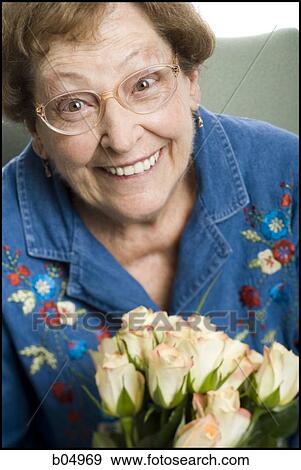 Elderly woman sitting in an armchair smiling View Large Photo Image Stock Photo - Elderly woman sitting in an armchair smiling. Fotosearch