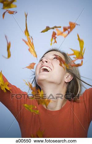 Falling leaves and woman with arms upstretched View Large Photo Image Stock Image - Falling leaves and woman with arms upstretched. Fotosearch