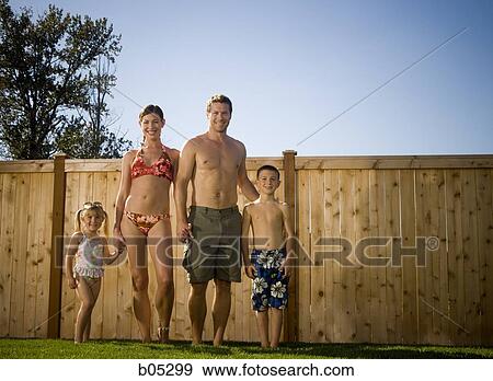 Family in bathing suits holding hands in yard View Large Photo Image Stock Photo - Family in bathing suits holding hands in yard. Fotosearch