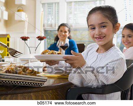Picture - Family sitting at dinner table. Fotosearch