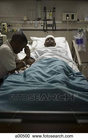 Father sitting by his son in hospital bed View Large Photo Image Stock Image - Father sitting by his son in hospital bed. Fotosearch