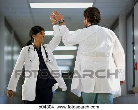 Female and male doctor giving high-five View Large Photo Image Picture - Female and male doctor giving high-five. Fotosearch