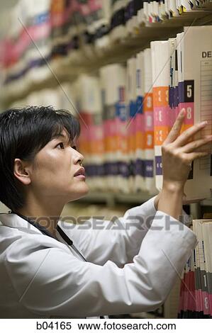 Female doctor looking through patient records View Large Photo Image Stock Photography - Female doctor looking through patient records. Fotosearch