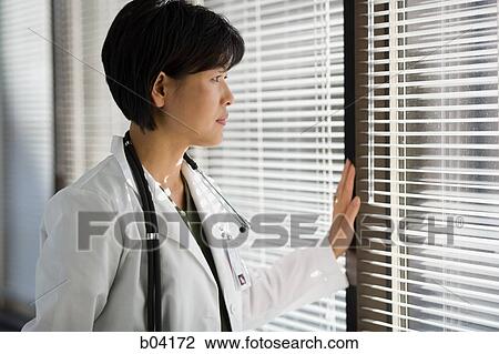 Female Doctor observing through blinds View Large Photo Image Stock Image - Female Doctor observing through blinds. Fotosearch