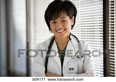 Female doctor smiling with arms crossed View Large Photo Image Stock Image - Female doctor smiling with arms crossed. Fotosearch