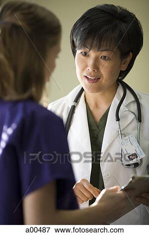 Female doctor talking to nurse View Large Photo Image Stock Photo - Female doctor talking to nurse. Fotosearch
