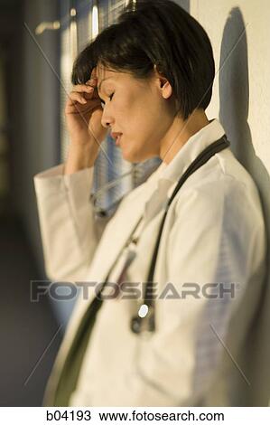 Stock Image - Female Doctor with hand on head. Fotosearch