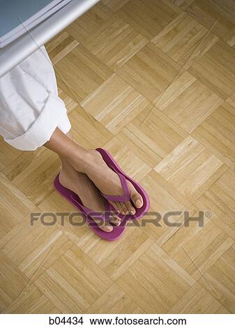 Female feet in thongs on hardwood floors View Large Photo Image Picture - Female feet in thongs on hardwood floors. Fotosearch