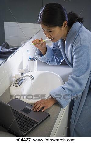 Female in bathroom with laptop and toothbrush View Large Photo Image Stock Photo - Female in bathroom with laptop and toothbrush. Fotosearch