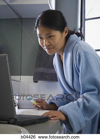 Female in bathroom with laptop and toothbrush View Large Photo Image Stock Photograph - Female in bathroom with laptop and toothbrush. Fotosearch