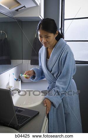 Female in bathroom with laptop and toothbrush View Large Photo Image Stock Photography - Female in bathroom with laptop and toothbrush. Fotosearch