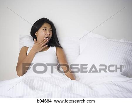Picture - Female in bed yawning. Fotosearch