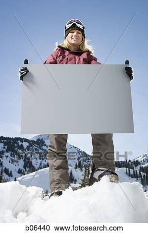 Female in the snow with a blank sign View Large Photo Image Stock Image - Female in the snow with a blank sign. Fotosearch