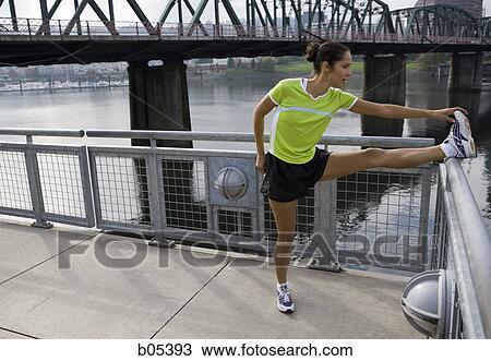 Stock Image - Female jogger stretching. Fotosearch