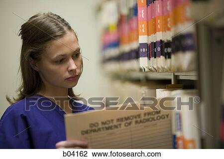 Female nurse looking at patient records View Large Photo Image Stock Image - Female nurse looking at patient records. Fotosearch