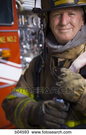 Fire fighter in uniform with firehose View Large Photo Image Stock Image - Fire fighter in uniform with firehose. Fotosearch