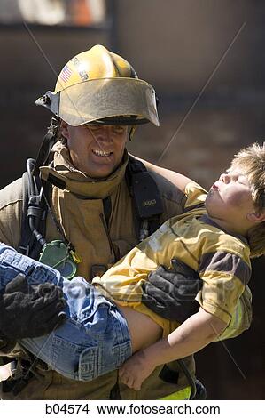 Fire fighter rescuing child View Large Photo Image Picture - Fire fighter rescuing child. Fotosearch