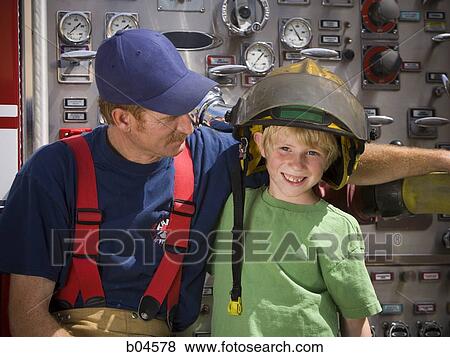 Fire fighter with young boy View Large Photo Image Stock Photo - Fire fighter with young boy. Fotosearch