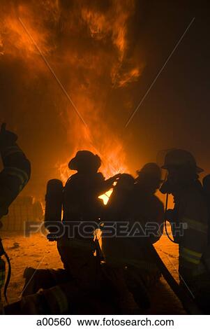 Stock Image - Firefighters at work rear view. Fotosearch