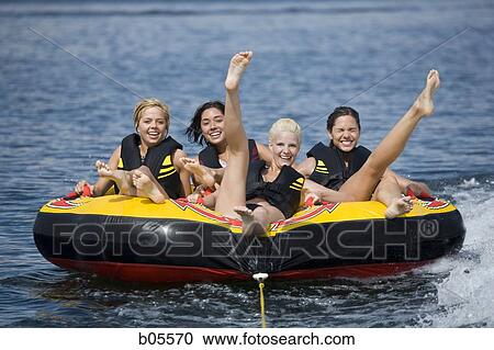 Four women on inner tube wearing life jackets View Large Photo Image Stock Image - Four women on inner tube wearing life jackets. Fotosearch
