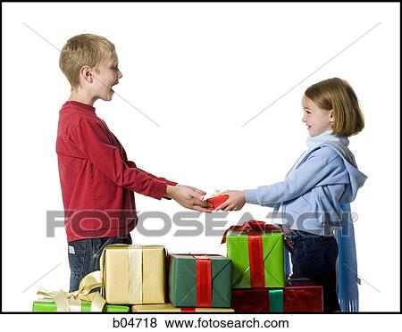 Girl giving Christmas gift to boy View Large Photo Image Stock Photo - Girl giving Christmas gift to boy. Fotosearch