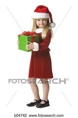 Stock Image - Girl in santa hat holding Christmas present. Fotosearch