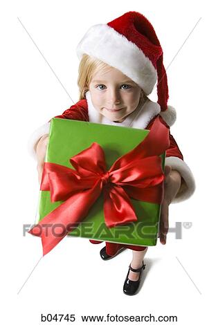 Stock Photography - Girl in santa hat holding Christmas present. Fotosearch