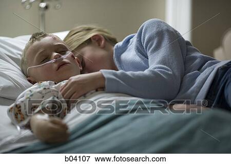Girl laying with brother on hospital bed View Large Photo Image Stock Photo - Girl laying with brother on hospital bed. Fotosearch