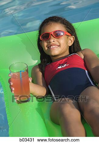Girl on pool lounger with pink lemonade View Large Photo Image Stock Image - Girl on pool lounger with pink lemonade. Fotosearch
