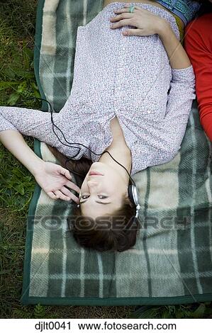 Girl on sleeping bag with headphones View Large Photo Image Stock Image - Girl on sleeping bag with headphones. Fotosearch