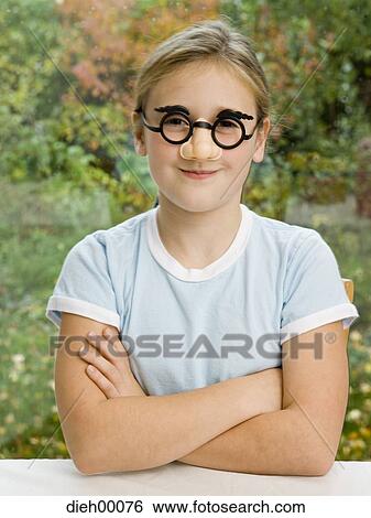 Stock Photograph - Girl outside wearing a fake nose and eyebrows. Fotosearch