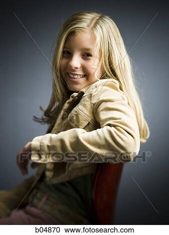 Girl sitting on chair smiling View Large Photo Image Stock Image - Girl sitting on chair smiling. Fotosearch