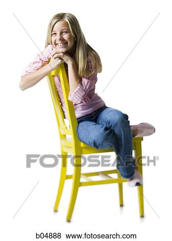 Girl sitting on yellow chair smiling View Large Photo Image Stock Photo - Girl sitting on yellow chair smiling. Fotosearch