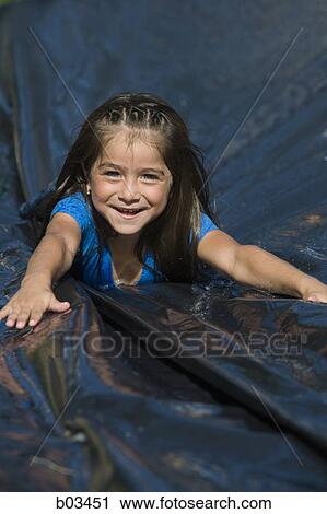 Stock Image - Girl sliding on tarpaulin. Fotosearch