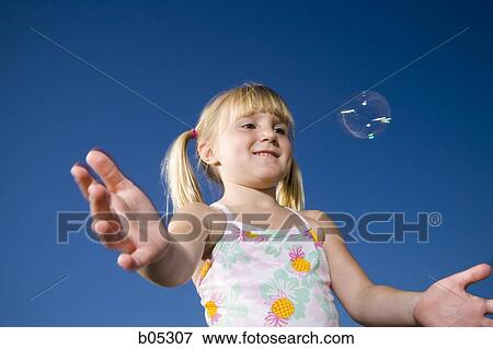Girl trying to catch bubble outdoors View Large Photo Image Stock Photo - Girl trying to catch bubble outdoors. Fotosearch