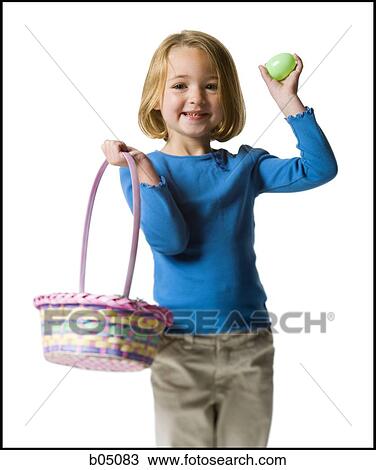 Stock Image - Girl with easter egg and basket. Fotosearch