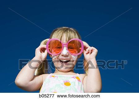 Girl with suntan lotion and sunglasses smiling View Large Photo Image Stock Photo - Girl with suntan lotion and sunglasses smiling. Fotosearch
