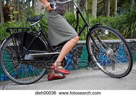 Half view of woman on bicycle View Large Photo Image Stock Photograph - Half view of woman on bicycle. Fotosearch