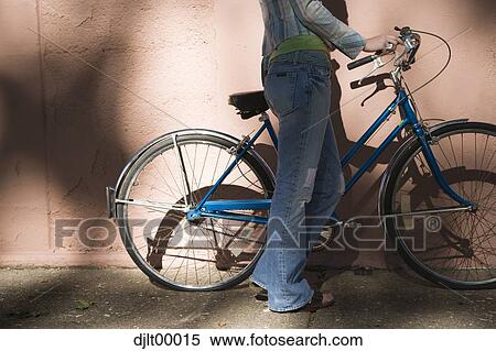 Stock Photography - Half view of woman with bicycle. Fotosearch