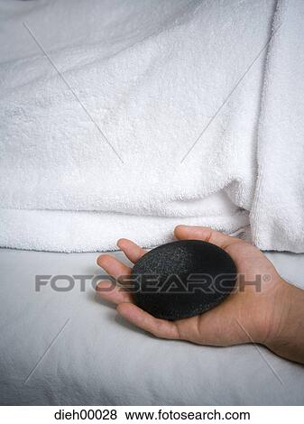 Hand holding a massage rock View Large Photo Image Stock Photo - Hand holding a massage rock. Fotosearch