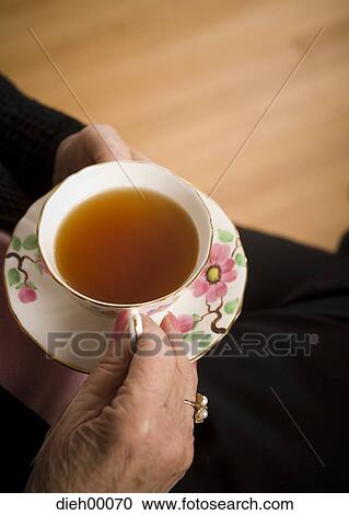 Stock Image - Hands holding a tea cup. Fotosearch